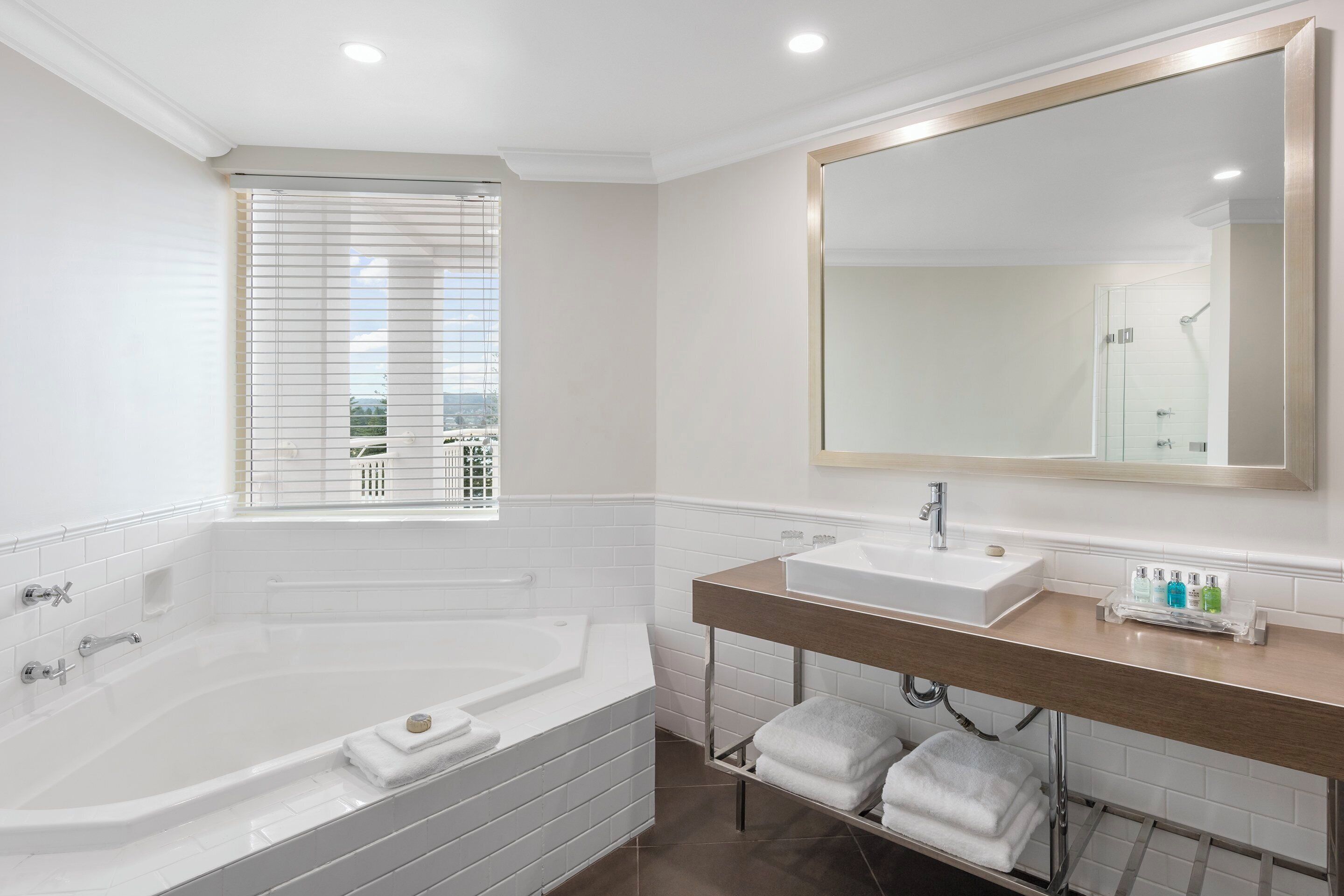 A modern bathroom with a bathtub, a sink, and a large mirror.
