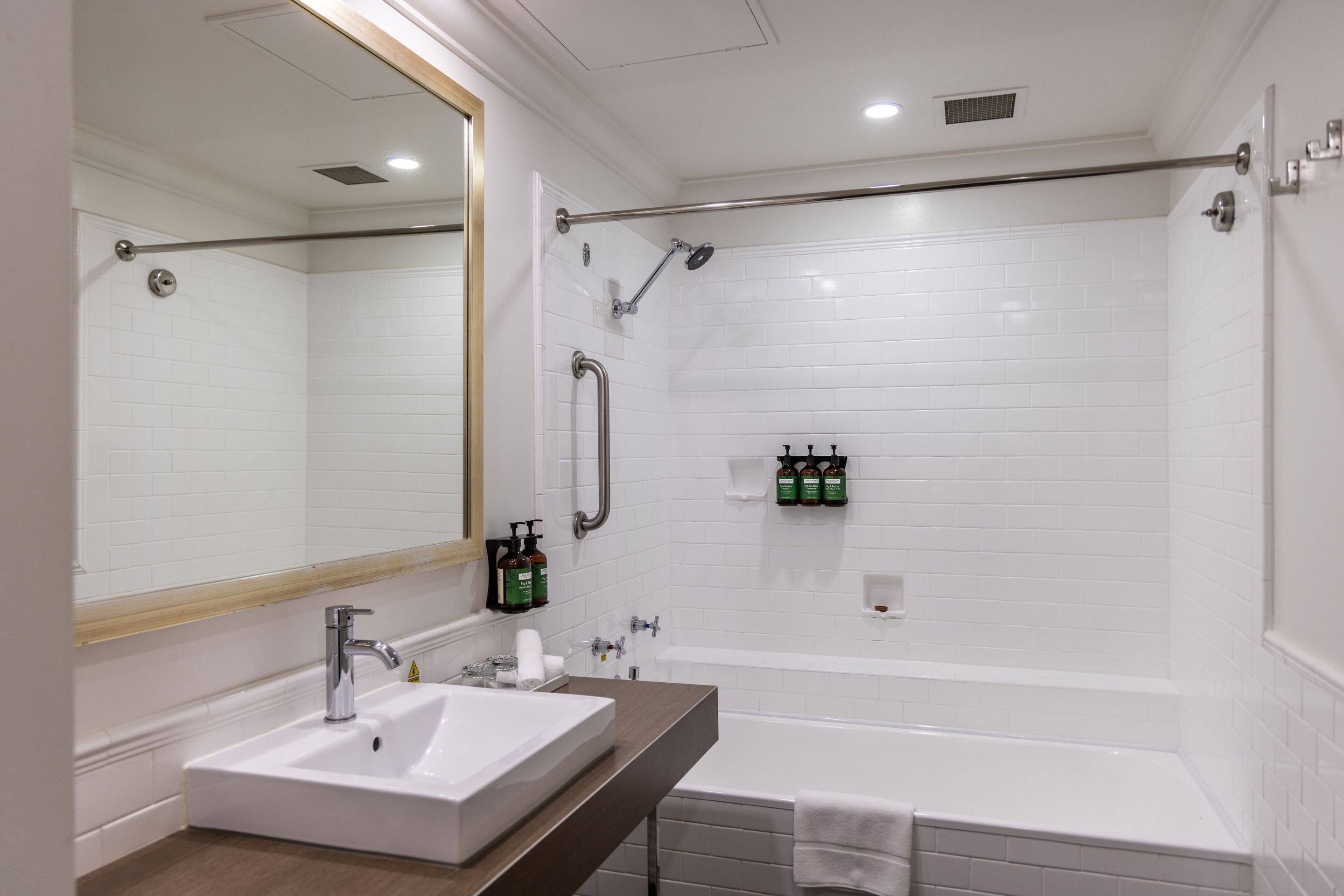 Une salle de bain moderne avec un lavabo blanc, un miroir et une douche.