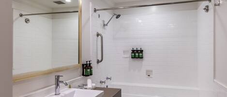 Une salle de bain moderne avec un lavabo blanc, un miroir et une douche.
