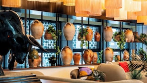 A room with a large bull sculpture, multiple vases, and hanging lamps. - Novotel Atria Nimes Centre (Nîmes)