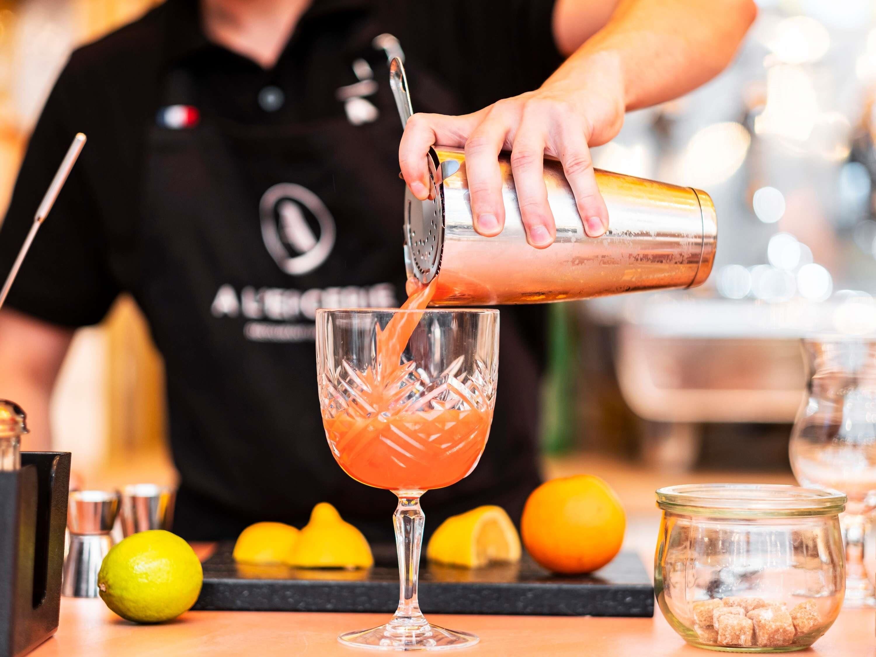 Ein Barkeeper gießt ein Getränk ein.