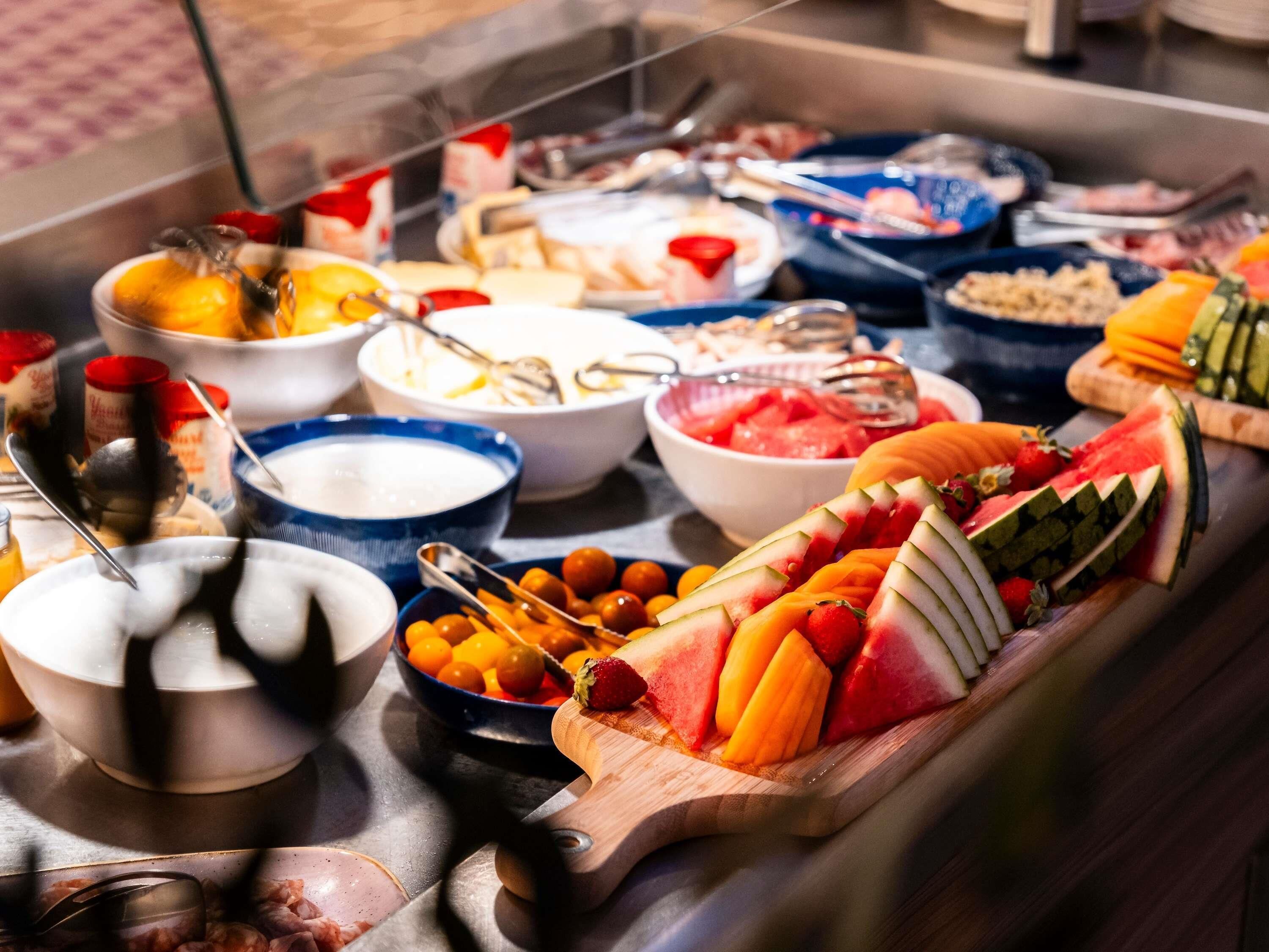 A buffet with various food items and utensils.