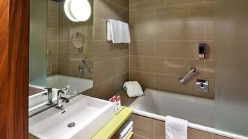 Ein Badezimmer mit Waschbecken, Spiegel und Badewanne.