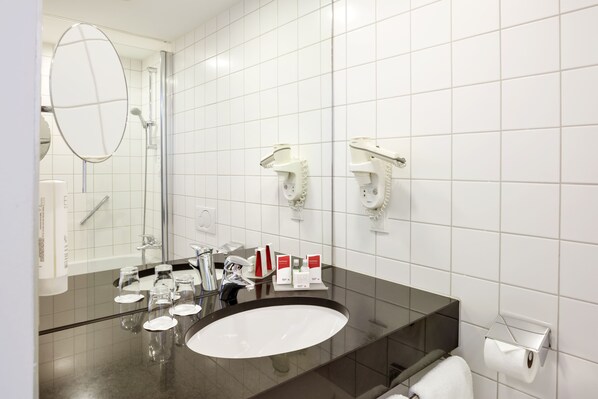 A modern bathroom with a large mirror, a round sink, and a towel rack. - Austria Trend Hotel Europa Wien (Vienna)