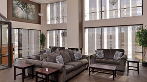 A spacious lobby with large windows, a sectional sofa, and a coffee table. - Quality Inn & Suites Matteson near I-57 (Matteson)