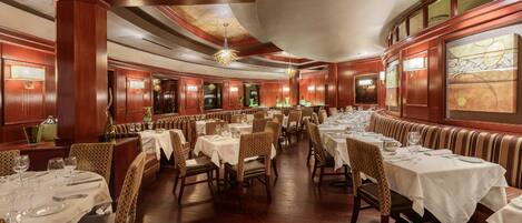 Un restaurante espacioso con varias zonas de comedor, cada una con mesas y sillas.