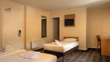 Een hotelkamer met twee bedden, een bureau, een stoel, een televisie en een spiegel.