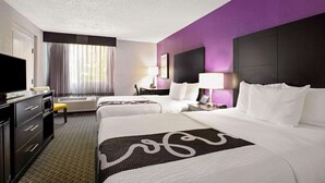 A hotel room with two beds, a desk with a flat-screen TV, a chair, a lamp, and a window with curtains. - La Quinta Inn & Suites by Wyndham Miami Lakes (Miami Lakes)