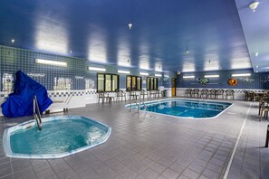 An indoor swimming pool with two separate sections, tiled walls, and seating areas. - Econo Lodge Luverne I-90 (Luverne)