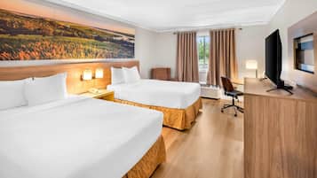 A hotel room with two beds, a desk, a television, and a painting of a landscape.