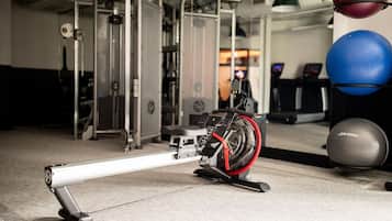 A stationary bike in a gym with exercise balls and weight machines in the background.