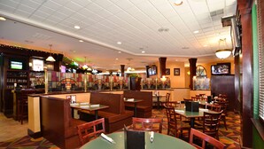 Ein Restaurant mit Sitzgelegenheiten in Boxen, Tischen und einer Bar.