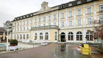 A historic building with a yellow facade, large windows, and a central entrance.