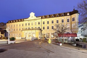A historic building with a classical facade, a central entrance, and a courtyard with seating areas. - Eurostars Park Hotel Maximilian (Regensburg)