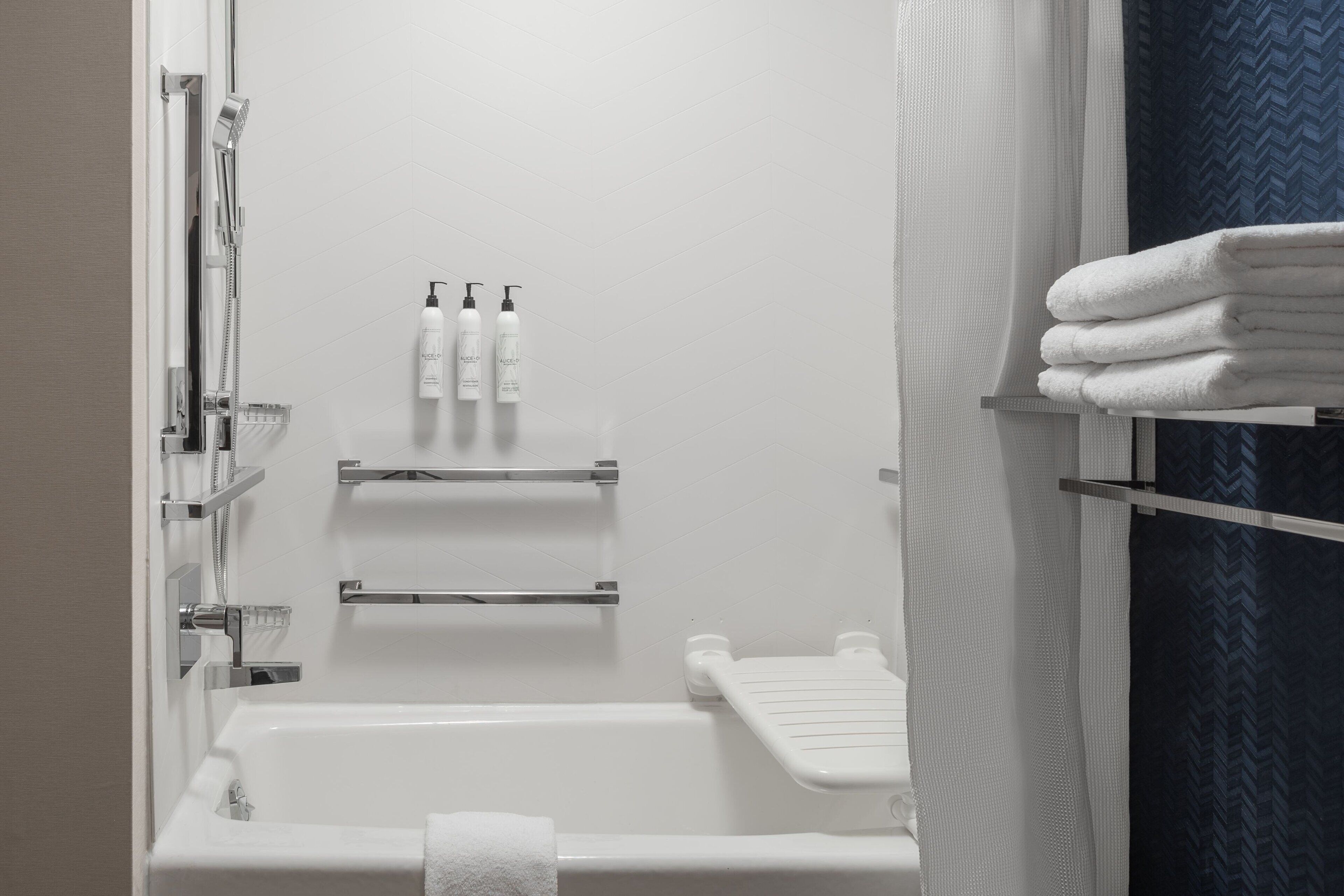 A bathroom with a bathtub, a shower, and a towel rack.