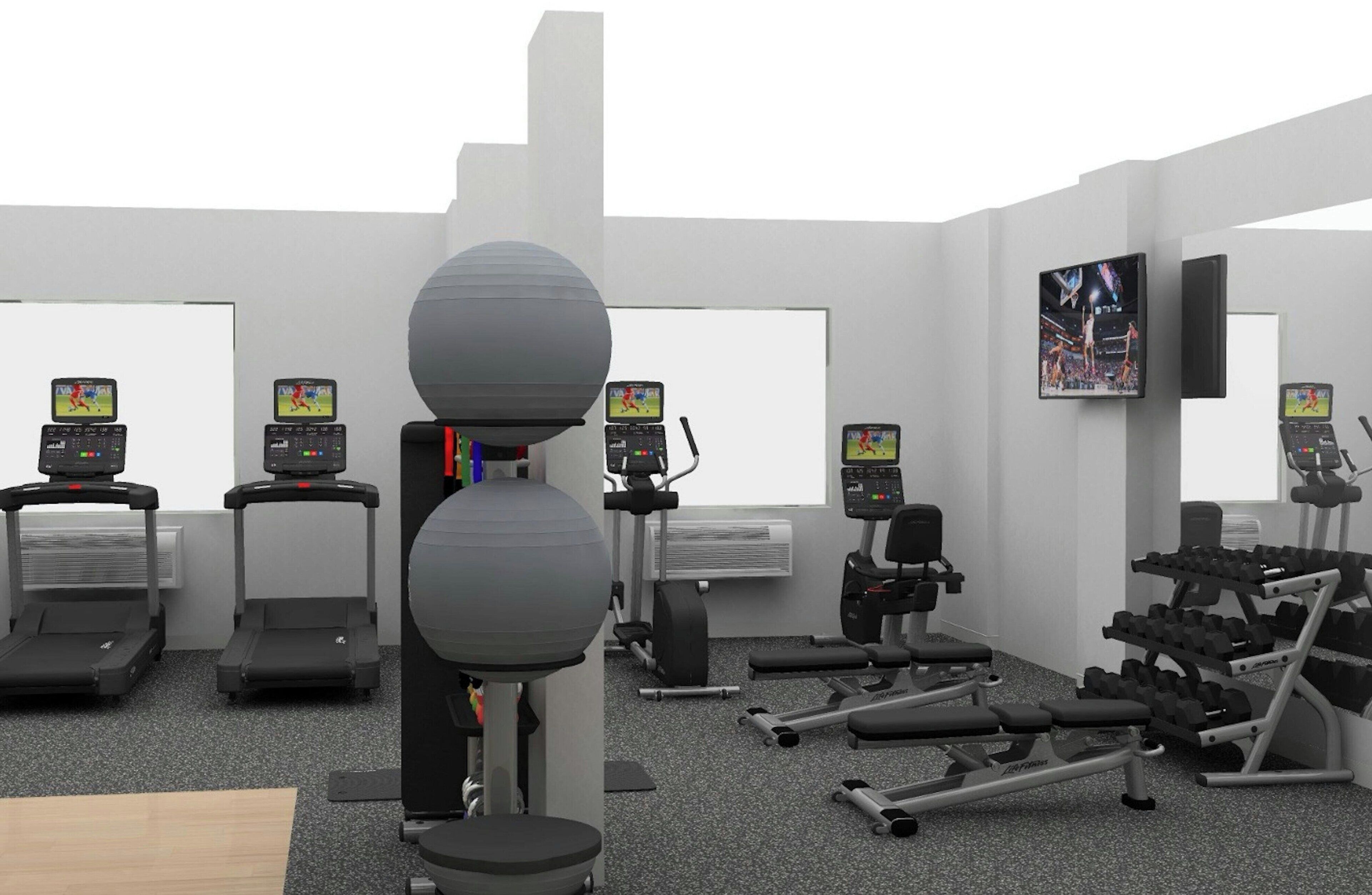 Une salle de sport équipée de tapis de course, d’un vélo d’appartement, d’un rameur et d’un ensemble d’haltères.