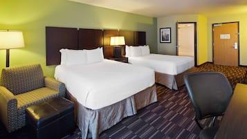 Habitación de hotel con dos camas, un sofá, una silla y un escritorio.