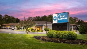 Un hotel Best Western con un letrero grande, rodeado de césped cuidado y árboles.