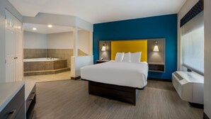 Una habitación de hotel moderna con una cama grande, baño independiente con bañera y vistas a la ciudad.