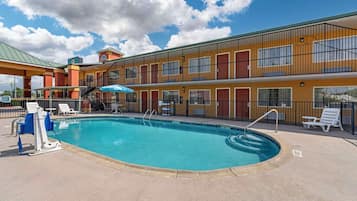 En säsongsöppen utomhuspool och solstolar