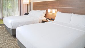 A hotel room with two beds, a nightstand with a phone and a lamp, and a window with curtains. - Holiday Inn Express South Burlington by IHG (South Burlington)