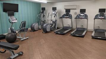 A gym with treadmills, elliptical machines, and a stationary bike.