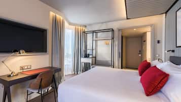 Ein Hotelzimmer mit Bett, Schreibtisch, Stuhl und Kleiderschrank.
