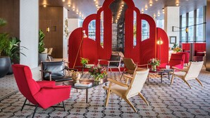 Un vestíbulo moderno con decoración roja, asientos cómodos y un suelo con diseño.