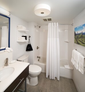 A modern bathroom with a shower, toilet, sink, and a towel rack.
