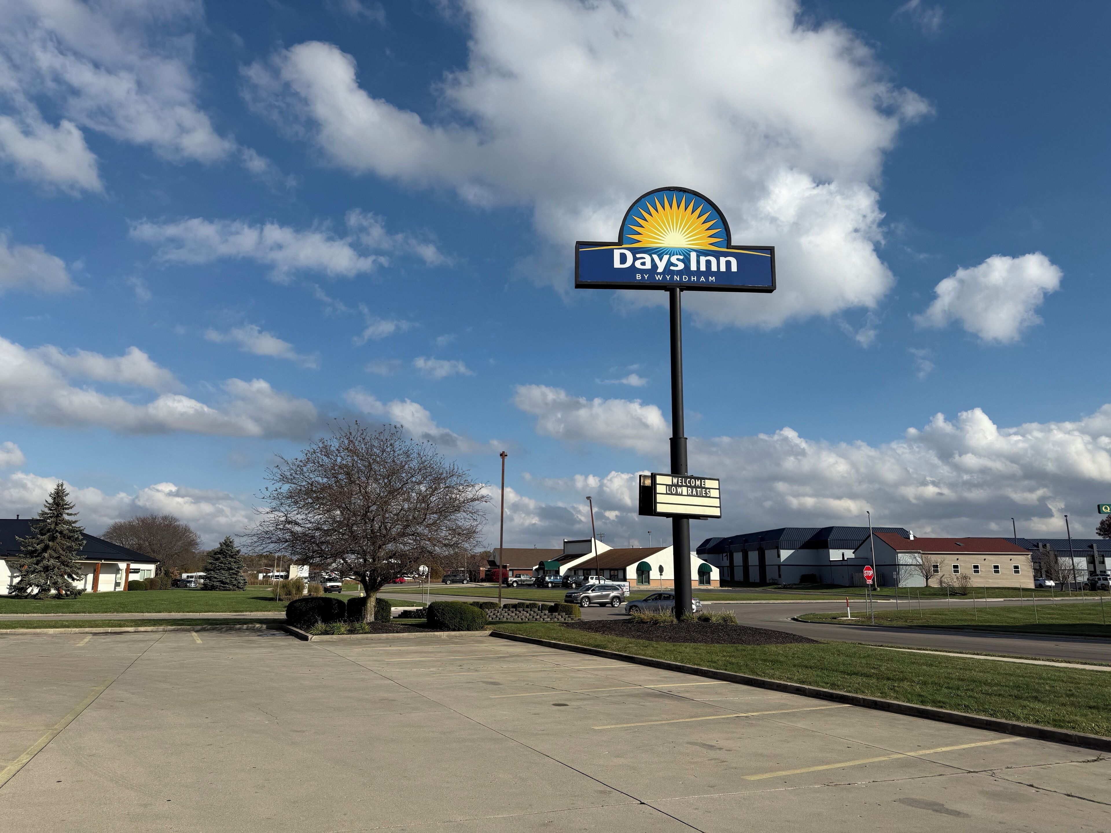 A Days Inn sign with a clear sky and parking lot.