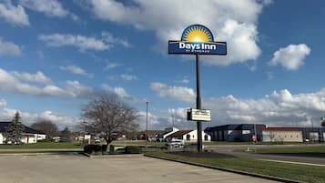 Señal de Days Inn con cielo despejado y estacionamiento.