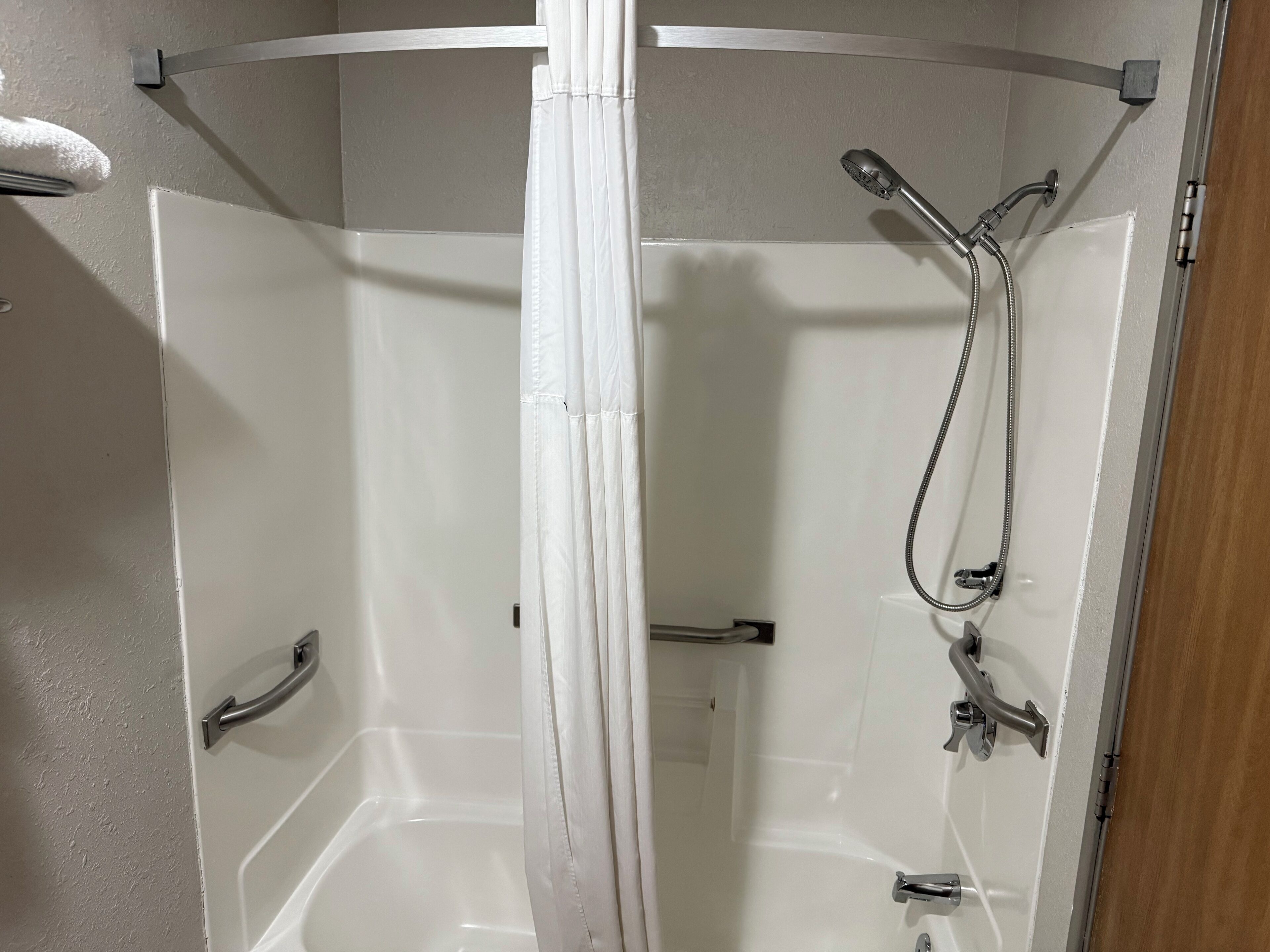 Une douche équipée d’un pommeau de douche et d’un robinet à main.
