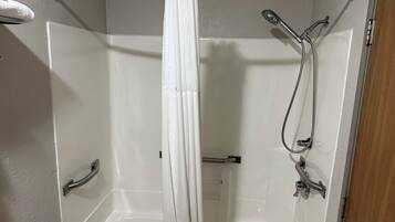 Une douche équipée d’un pommeau de douche et d’un robinet à main.