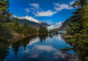 A serene lake surrounded by snow-capped mountains and dense forest. - Four Points by Sheraton Juneau (Juneau)