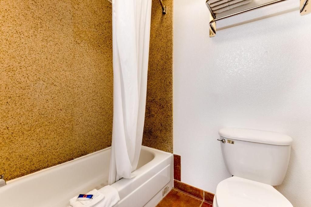 Ein Badezimmer mit Badewanne, Toilette und Handtuchhalter.