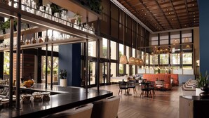 A modern restaurant with a bar area, seating, and large windows. - Hotel Fera Anaheim, a DoubleTree by Hilton (Orange)