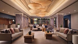 A spacious lobby with a bar area, comfortable seating, and a modern ceiling design. - Hotel Fera Anaheim, a DoubleTree by Hilton (Orange)