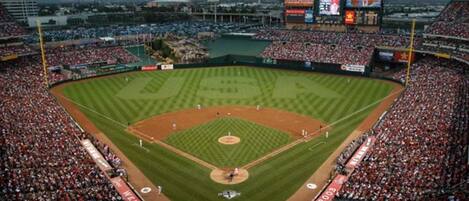 A baseball stadium with multiple seating tiers, a central field, and a large crowd.