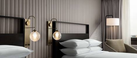 Una habitación de hotel moderna con una cama grande, dos mesitas de noche y una lámpara.