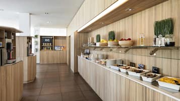 Un bar à petit-déjeuner moderne, avec un revêtement mural en bois, une machine à café et divers aliments exposés sur des étagères.