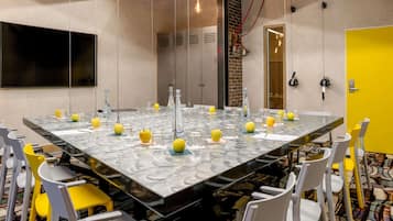 Une salle de conférence avec une grande table, des chaises et une porte jaune.