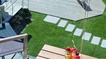 Ein Balkon mit Tisch, Orangensaft und einem Obstdessert.