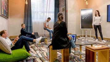 Une salle de réunion moderne dotée d’un grand écran, de sièges confortables et d’un sol à motifs.