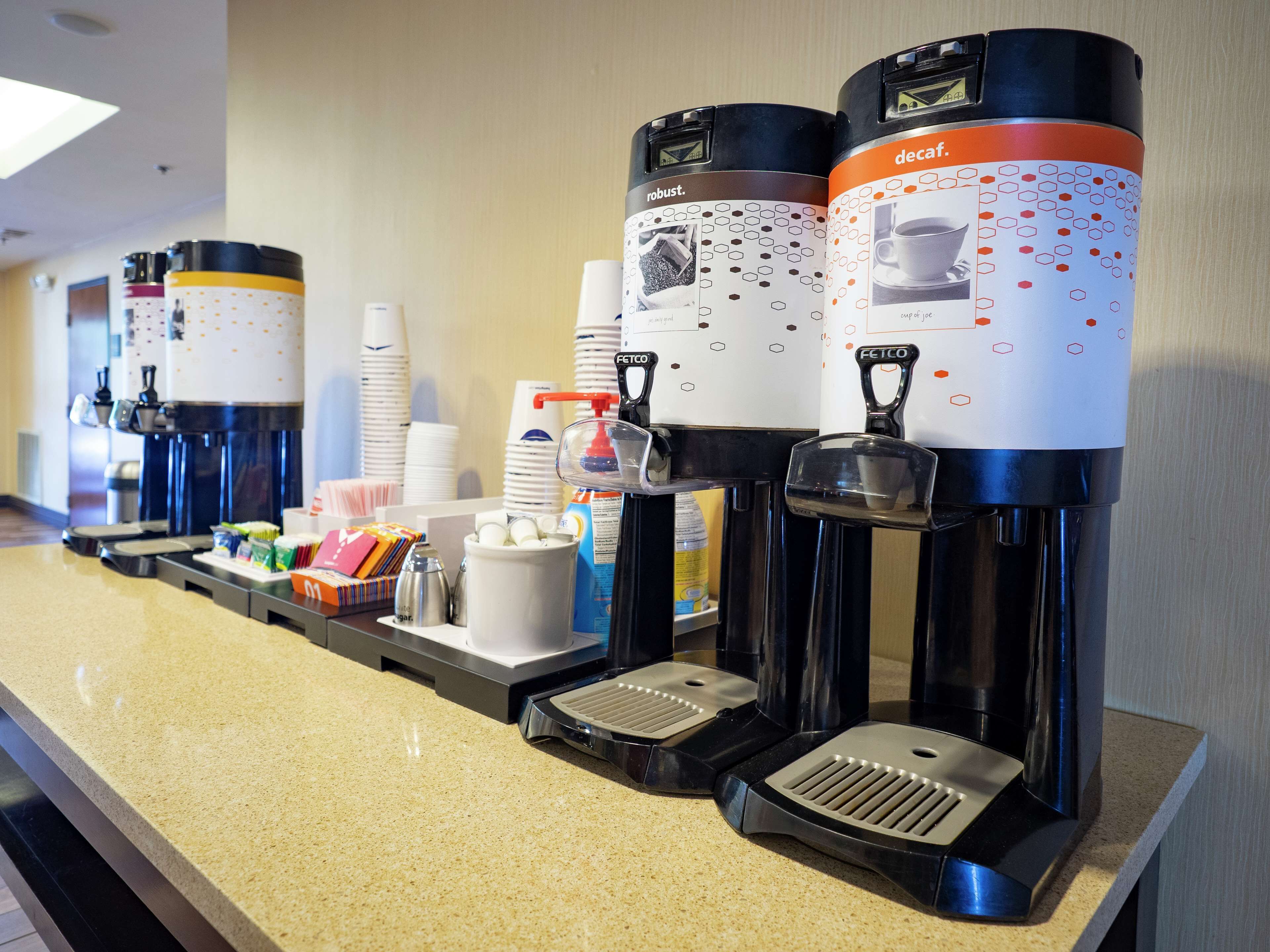 A coffee station with multiple coffee dispensers, a scale, and various coffee-related items.