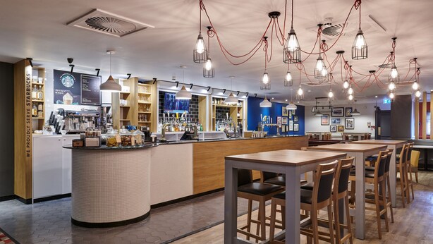 A modern Starbucks with a barista station, seating area, and various Starbucks products on display. - Holiday Inn Leeds Garforth by IHG (Leeds)