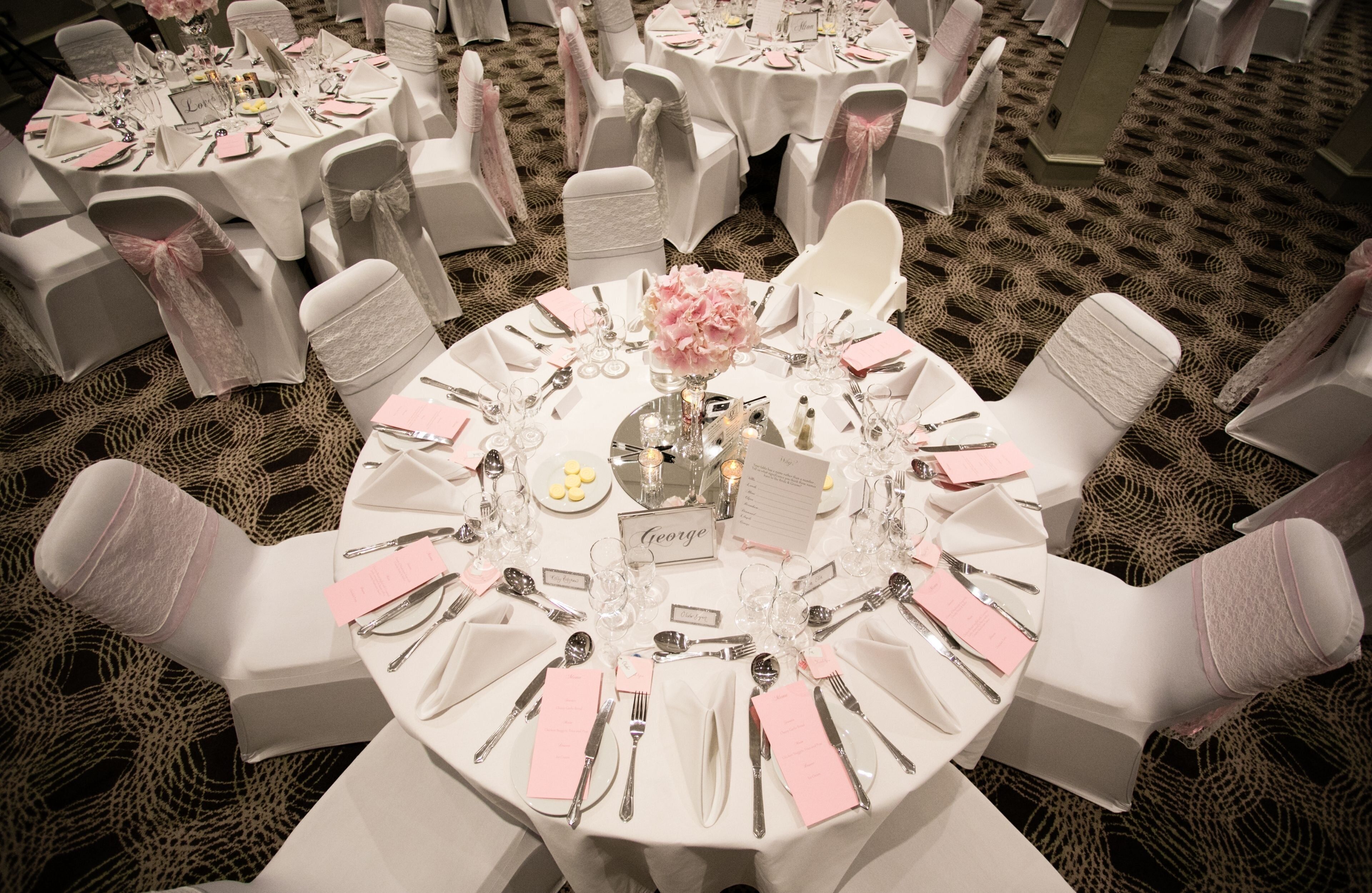 A round table set for a formal event with chairs around it.