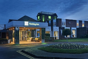 A Holiday Inn hotel with a modern design, featuring a prominent entrance and a rooftop structure.