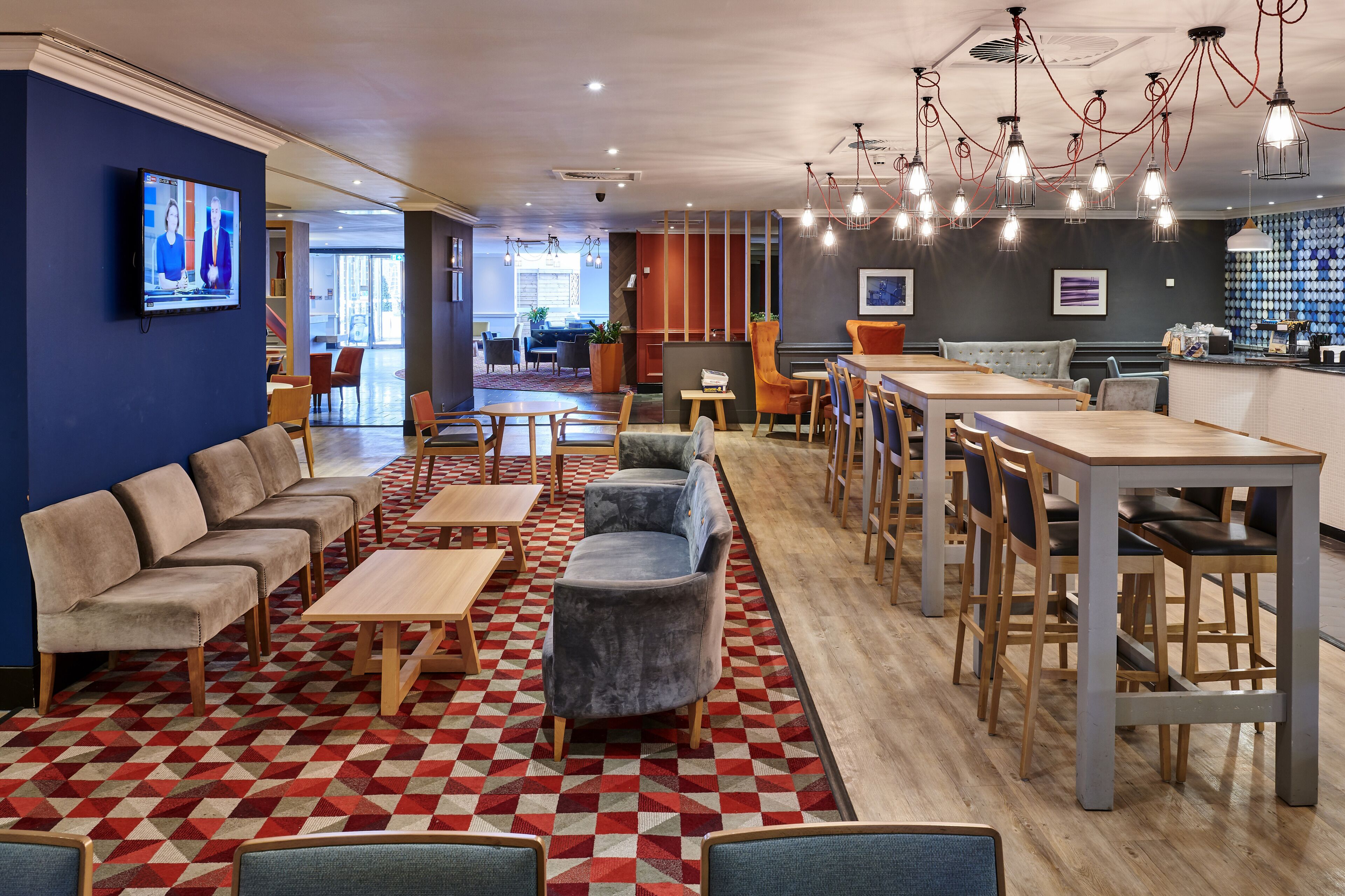 Ein moderner Lounge-Bereich mit Sofas, Tischen und einer Bar.