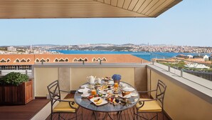 A balcony with a table set for breakfast overlooking a cityscape and a body of water. - Divan Istanbul (Istanbul)