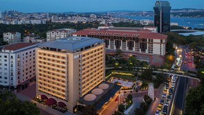 A multi-story hotel with a prominent 'divan' sign, surrounded by other buildings and a busy road with vehicles. - Divan Istanbul (Istanbul)